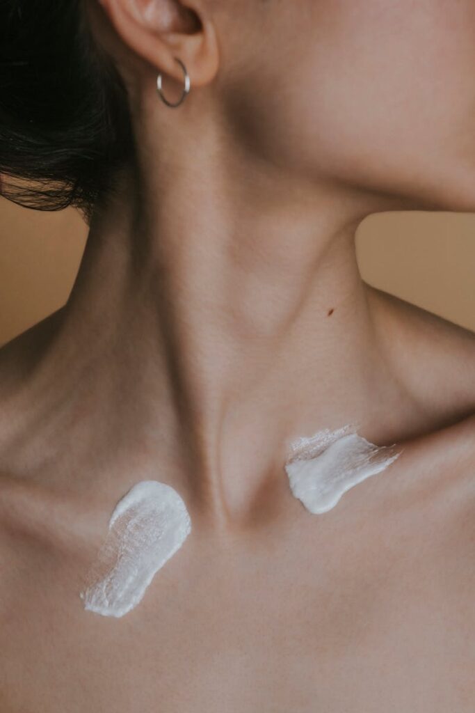 pexels-photo-20469562-20469562-1 Detailed image showing a woman's neck with skincare cream applied in a studio setting.